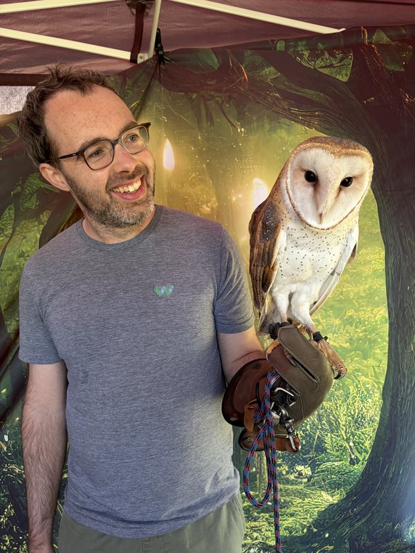 Paul holding a barn owl on a falconry glove